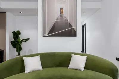 a green couch in a living room with a picture on the wall at Waves - Tranquil Waterfront Living 2B Retreat With Balcony in Dubai