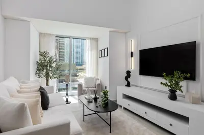 a white living room with a white couch and a tv at Maison Privee - Sleek Stay in Dubai Marina Famous Twisting Tower in Dubai