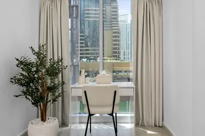 a white chair in a room with a large window at Maison Privee - Sleek Stay in Dubai Marina Famous Twisting Tower in Dubai