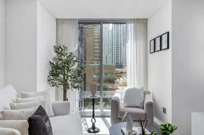 a living room with white furniture and a large window at Maison Privee - Sleek Stay in Dubai Marina Famous Twisting Tower in Dubai