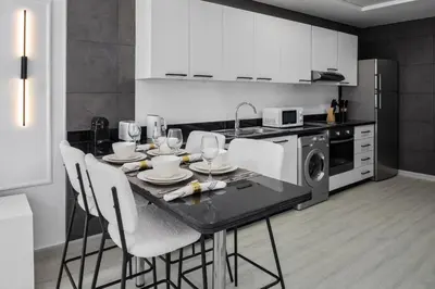 a kitchen with a table with chairs and a microwave at Maison Privee - Sleek Stay in Dubai Marina Famous Twisting Tower in Dubai