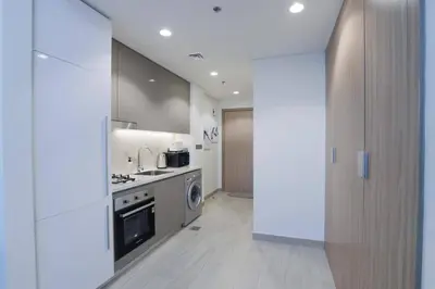 a kitchen with a stove and a washer and dryer at Azizi Riviera 42 - Meydan by Golden Casa in Dubai