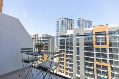 a table and two chairs on a balcony with buildings at Azizi Riviera 42 - Meydan by Golden Casa in Dubai