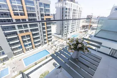 a vase of flowers sitting on a bench on a balcony at Azizi Riviera 42 - Meydan by Golden Casa in Dubai