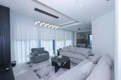a living room with a couch and a table at Sobha Hartland Waves-912 in Dubai