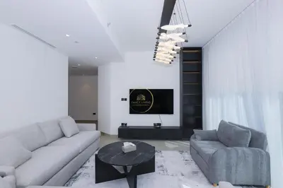a living room with a couch and a table at Sobha Hartland Waves-912 in Dubai