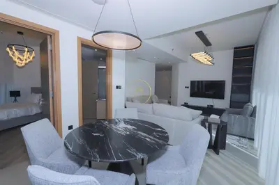 a living room with a table and chairs and a couch at Sobha Hartland Waves-912 in Dubai