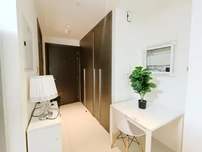 a room with a desk and a table with a lamp at SUPERIOR STAY HOLIDAY HOMES - Sleek & Modern Studio in Business Bay in Dubai