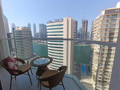 a balcony with chairs and tables and a view of a city at SUPERIOR STAY HOLIDAY HOMES - Sleek & Modern Studio in Business Bay in Dubai