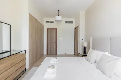 a white bedroom with a large white bed with white pillows at Partial Canal View, Business Bay in Dubai