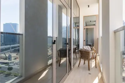 a balcony with glass doors and a table and chairs at Partial Canal View, Business Bay in Dubai
