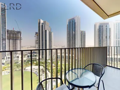 a balcony with a table and chairs and a city at Luxurious 1BR Apartment with Creek View in Dubai