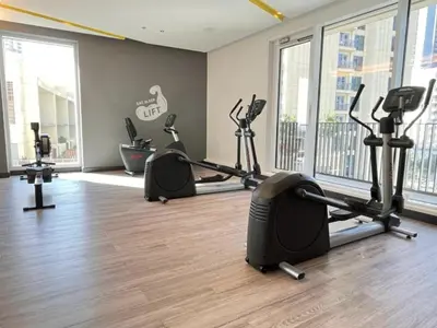 a gym with several treadmills and elliptical machines at Luxurious 1BR Apartment with Creek View in Dubai