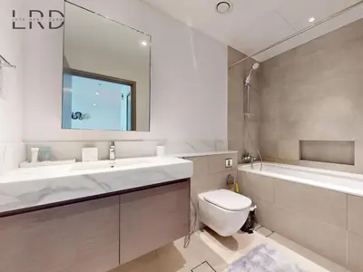 a bathroom with a sink and a toilet and a tub at Luxurious 1BR Apartment with Creek View in Dubai