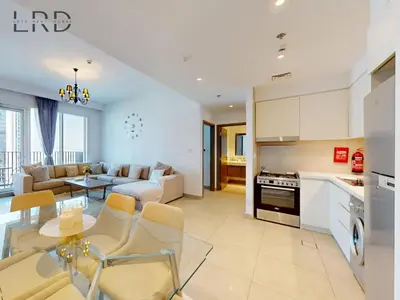 a kitchen and living room with a couch and a table at Luxurious 1BR Apartment with Creek View in Dubai