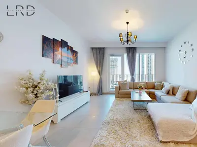 a living room with a couch and a tv at Luxurious 1BR Apartment with Creek View in Dubai