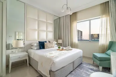 a bedroom with a large bed and a blue chair at GuestReady - Peaceful Skyline at Signature Tower in Dubai