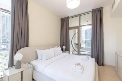 a bedroom with a white bed and a large window at Premium Apartment, Right Infront of Canal in Dubai
