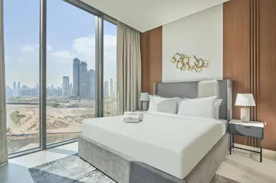 a bedroom with a large white bed and large windows at STAY BY LATINEM Luxury 1BR Holiday Home CVG 1410 Near Burj Khalifa in Dubai