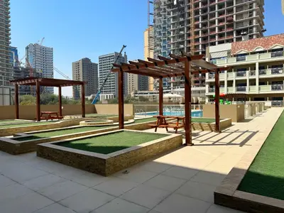 a park with picnic tables and benches in a city at Modern & Stylish Studio Retreat in Dubai