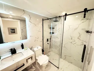 a bathroom with a shower and a toilet and a sink at Modern & Stylish Studio Retreat in Dubai