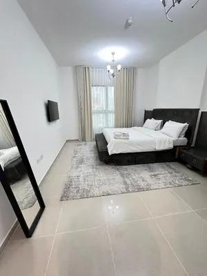 a bedroom with a bed and a large window at Bright 1BR Apartment in JVC - JLiving in Dubai