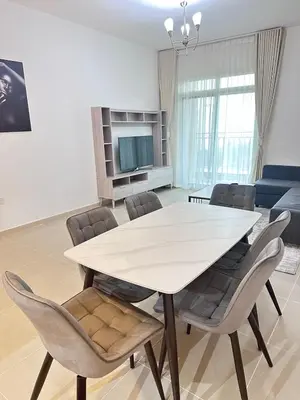 a dining room with a white table and chairs at Bright 1BR Apartment in JVC - JLiving in Dubai