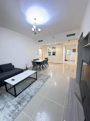 a living room with a couch and a table at Bright 1BR Apartment in JVC - JLiving in Dubai