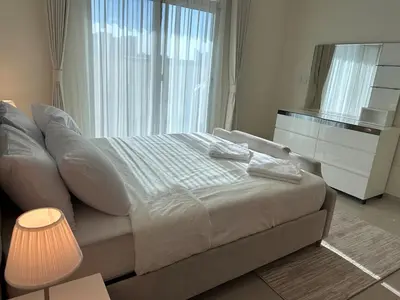 a bedroom with a bed and a large window at 1BR Apartment with Private Jacuzzi in JVC - JLiving in Dubai