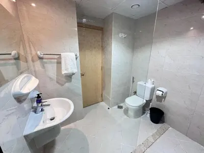 a bathroom with a white sink and a toilet at 1BR Apartment with Private Jacuzzi in JVC - JLiving in Dubai