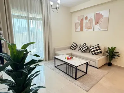 a living room with a couch and a coffee table at 1BR Apartment with Private Jacuzzi in JVC - JLiving in Dubai