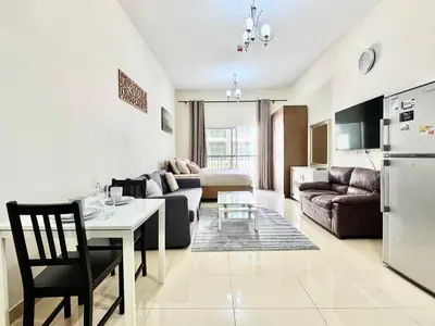 a living room with a couch and a table at Homes2Retreat - Very Spacious Studio in the Heart of JVC in Dubai