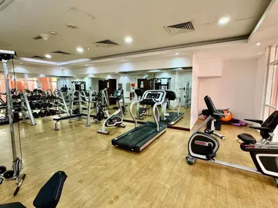 a gym with several treadmills and exercise bikes at Homes2Retreat - Very Spacious Studio in the Heart of JVC in Dubai