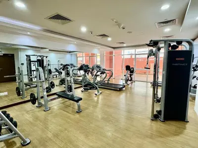 a gym with several tread machines in a room at Homes2Retreat - Very Spacious Studio in the Heart of JVC in Dubai