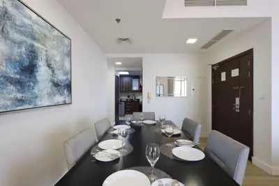 a dining room with a table and chairs and a painting at Livbnb-Serene 2B with Marina and Sea View Walk to Beach in Dubai