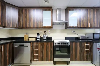 a kitchen with wooden cabinets and a stove top oven at Livbnb-Serene 2B with Marina and Sea View Walk to Beach in Dubai