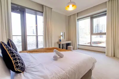 a bedroom with a large bed with large windows at Luxurious 2Bed in Sparkle Tower-Marina View in Dubai