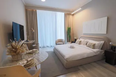 a bedroom with a bed and a table and a television at Modern Studio in Condor Concept7, JVC in Dubai