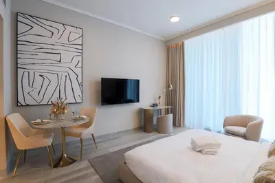 a bedroom with a bed and a table and a tv at Modern Studio in Condor Concept7, JVC in Dubai