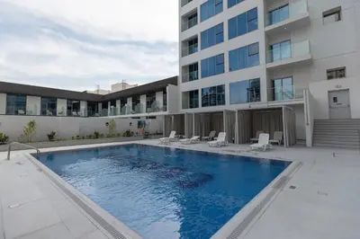 a swimming pool in front of a building at Modern Studio in Condor Concept7, JVC in Dubai