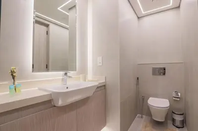 a white bathroom with a sink and a toilet at Modern Studio in Condor Concept7, JVC in Dubai