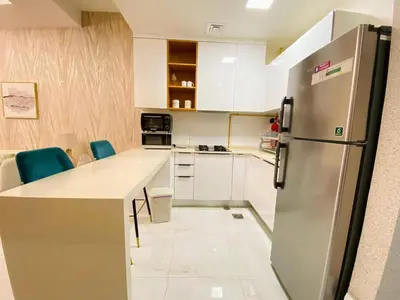a kitchen with white cabinets and a stainless steel refrigerator at Dubai Luxury Apartments In a good place in Dubai