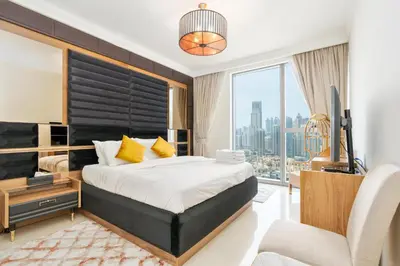 a bedroom with a large bed and a large window at King 2BR With Burj Khalifa View In Boulevard Point in Dubai