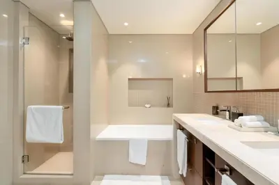 a bathroom with two sinks and a shower at King 2BR With Burj Khalifa View In Boulevard Point in Dubai
