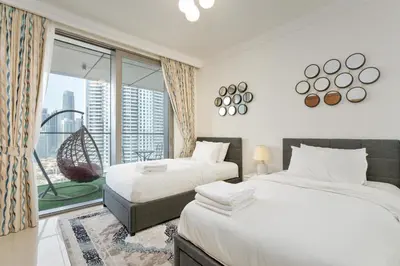 a bedroom with two beds and a large window at King 2BR With Burj Khalifa View In Boulevard Point in Dubai