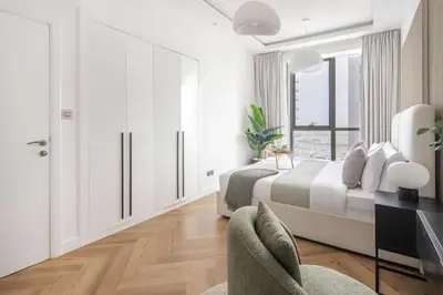 a white bedroom with a bed and a window at Frank Porter - Torch Tower in Dubai