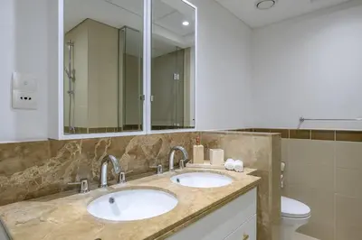 a bathroom with two sinks and a toilet at Luxury Apartment with Full Burj & Fountain Views in Dubai
