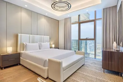 a bedroom with a large white bed and a large window at Two Bedroom Apartment in Nobles Tower by The S Holiday Homes in Dubai