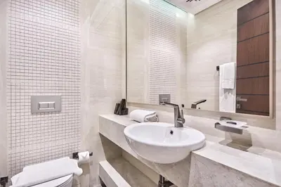 a white bathroom with a sink and a toilet at Two Bedroom Apartment in Nobles Tower by The S Holiday Homes in Dubai