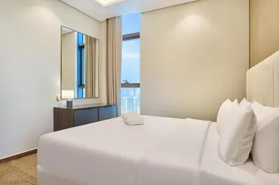 a white bed in a room with a window at Two Bedroom Apartment in Nobles Tower by The S Holiday Homes in Dubai